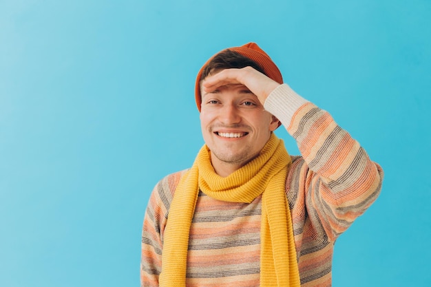 Beau jeune homme en vêtements d'hiver sur fond de couleurxA