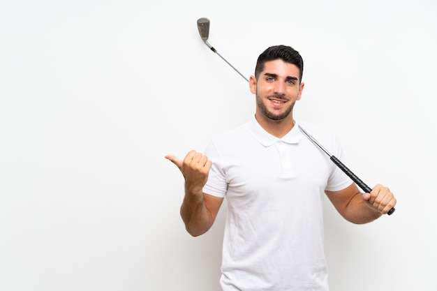 Beau jeune joueur de golfeur homme sur blanc isolé pointant sur le côté pour présenter un produit