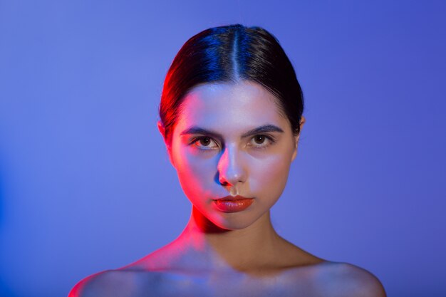 Beau jeune mannequin femme portrait lèvres rouges composent en studio de lumière bleu rouge