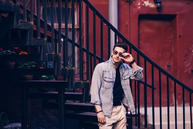 Beau jeune mannequin d'un homme portant des lunettes de soleil