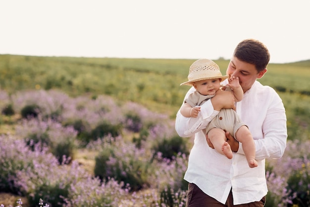 Beau jeune papa jouant avec son fils dans un champ de lavande