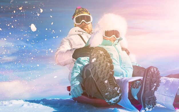 Beau jeune papa et sa petite fille mignonne s'amusent en plein air en hiver. Aimer passer du temps ensemble. Notion de famille.