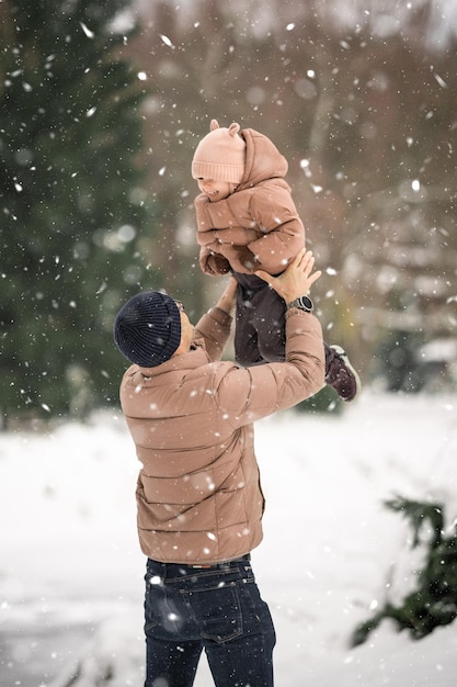 Beau jeune papa et sa petite fille mignonne s'amusent en plein air en hiver Profitant de passer du temps ensemble Concept de famille