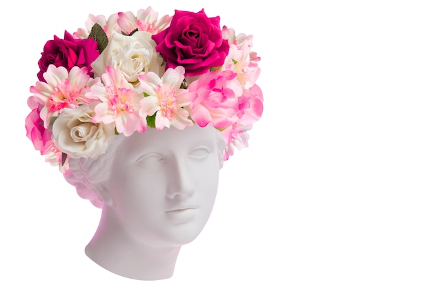 Beau jeune visage féminin et fleurs colorées. Buste antique en plâtre de Vénus de Milo dans une couronne de fleurs. Fille modèle printemps et été de beauté avec bouquet frais.