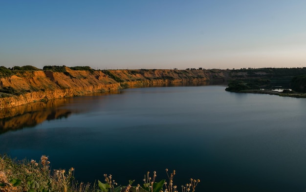 Un beau lac dans une carrière abandonnée profonde Heure d'été Coucher du soleil du soir Paysage Photo horizontale