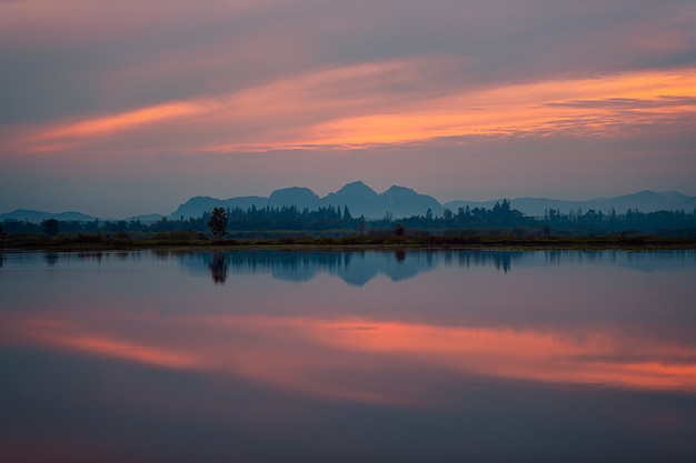 Beau lever de soleil avec ciel rouge et reflet dans le lac.