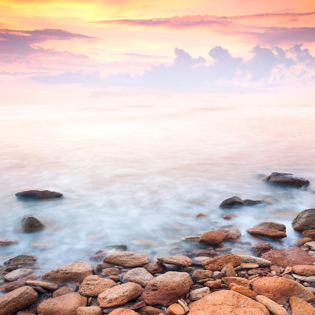 Photo beau lever de soleil sur la côte rocheuse de la mer