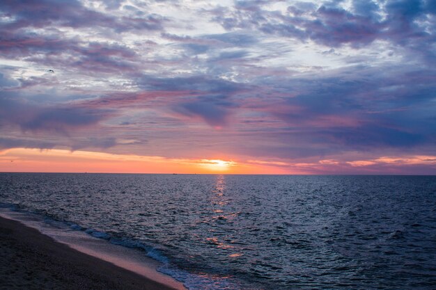 Beau lever de soleil en mer avec des nuages