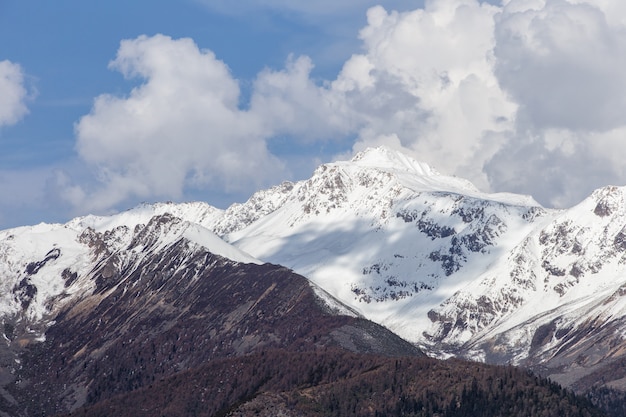 Beau lever de soleil nuageux dans les montagnes avec la crête de neige