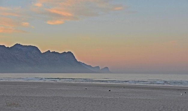 Un beau lever de soleil sur la plage de Strand et les montagnes d'Overberg