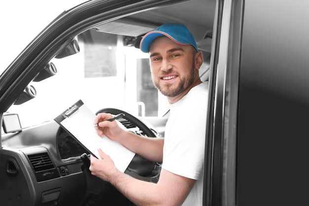 Beau livreur assis dans la voiture