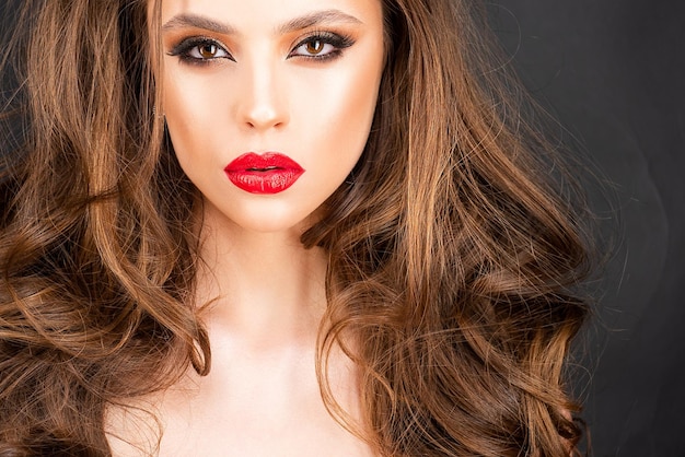 Beau maquillage professionnel Lèvres rouges et yeux charbonneux composent une mode glamour magnifique