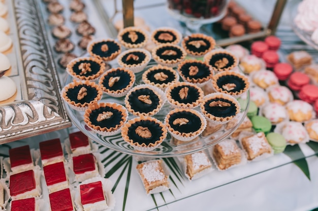 Beau mariage buffet sucré avec décor et vert.