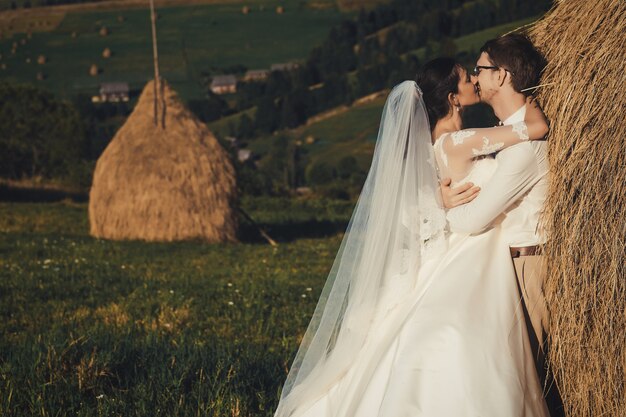 Beau mariage à la montagne, un jeune couple heureux près du grenier à foin.