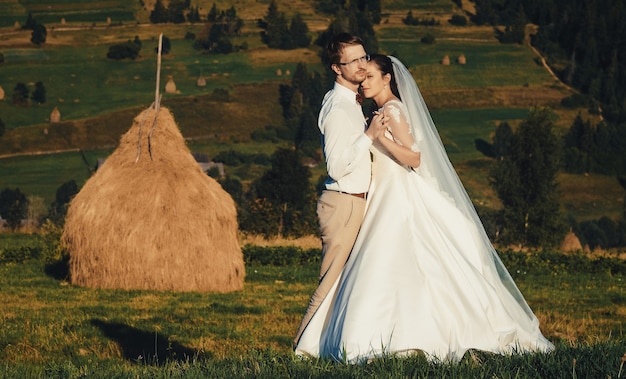 Beau mariage à la montagne, un jeune couple heureux près du grenier à foin.