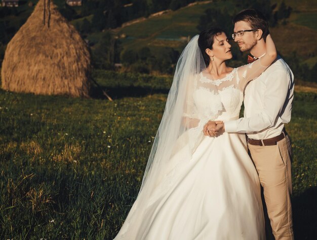 Beau mariage à la montagne un jeune couple heureux près du grenier à foin