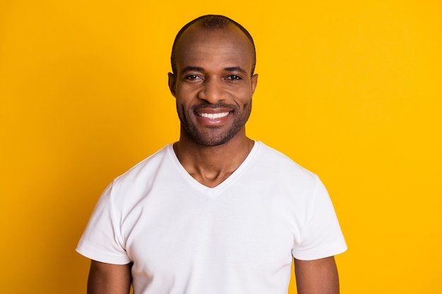 beau mec africain masculin posant sur un mur jaune