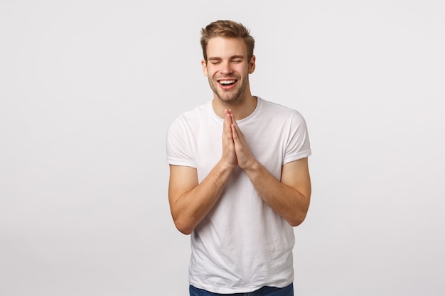 Beau mec blond aux yeux bleus et T-shirt blanc en espérant réussir