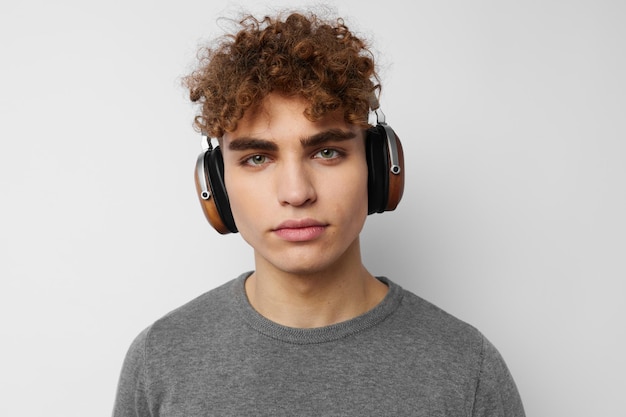 Beau mec dans un pull gris casque mode fond clair