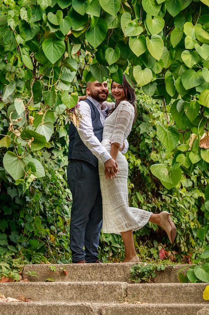 Photo beau mec avec des fleurs embrasse sa fiancée