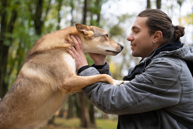 Un beau mec joue et parle avec un chien