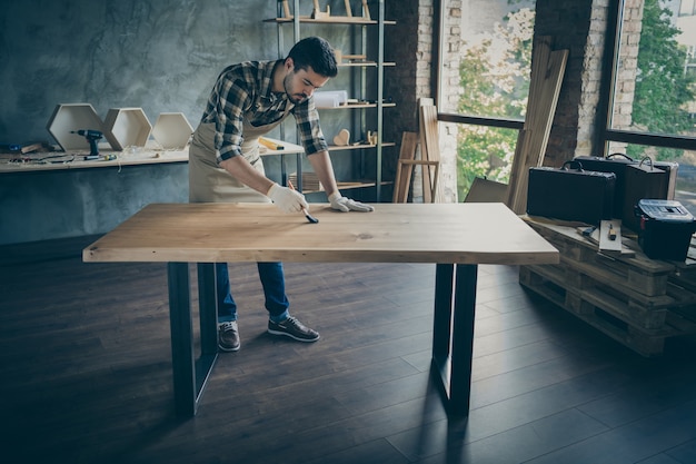 Beau mec prudent sur toute la longueur couvrant la table de dalle à la main vernis à l'huile pinceau de peinture propre industrie du bois de l'industrie du bois garage garage à l'intérieur