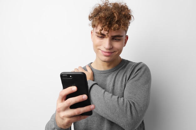 Beau mec regardant le mode de vie du téléphone inchangé