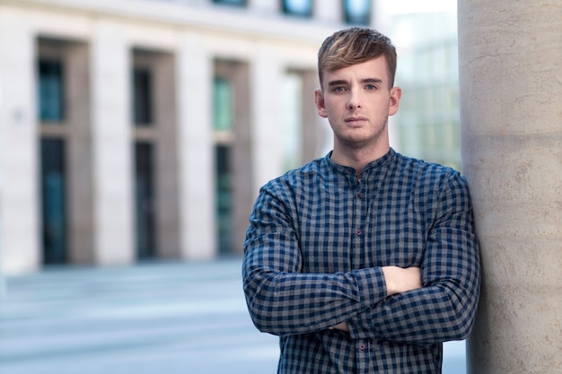 Beau mec sérieux, jeune bel homme européen debout avec ses mains, les bras croisés, à l'extérieur. Copiez l'espace, placez le texte. Garçon confiant élégant en chemise.