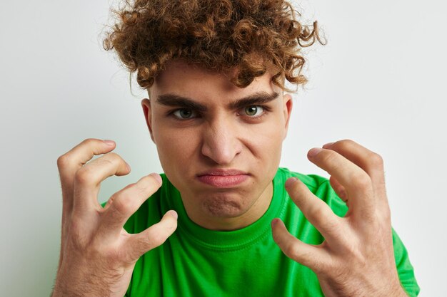 Beau mec en t-shirts verts émotions posant fond isolé