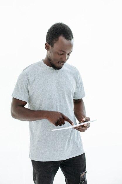 Beau mec tapant sur l'écran de la tablette numérique. isolé sur fond blanc