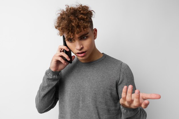 Beau mec avec un téléphone à la main communication fond isolé