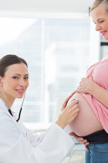 Beau médecin examinng femme enceinte