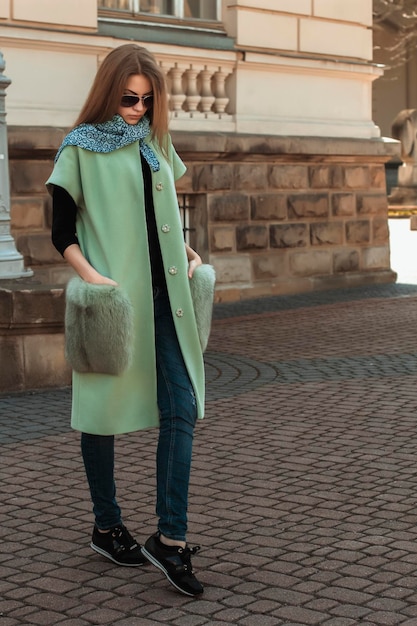 Beau modèle blond dans un manteau vert à la mode