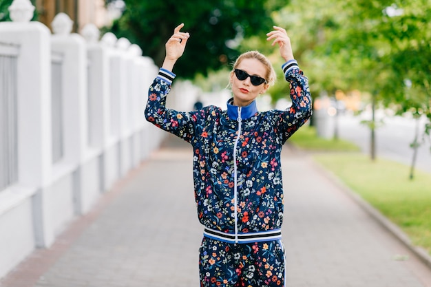 Beau modèle blonde élégante en costume coloré posant dans la rue