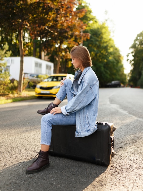 Beau modèle brune posant sur une valise