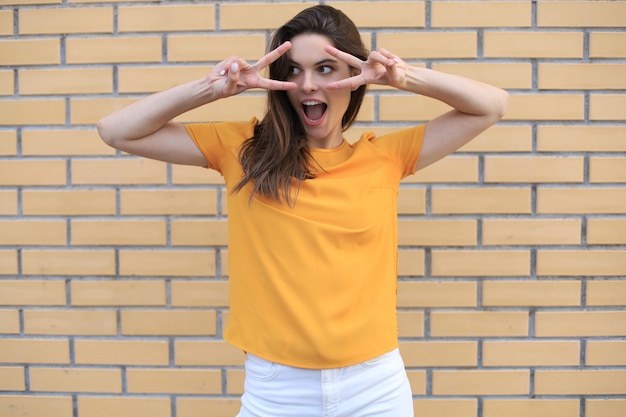 Beau modèle brune souriante vêtue de vêtements d'été hipster. Femme drôle et positive s'amusant.