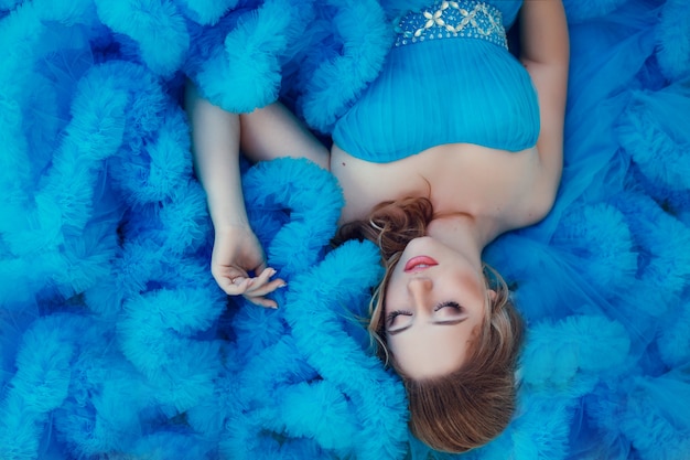 Beau modèle dans une robe bleue sur neutre