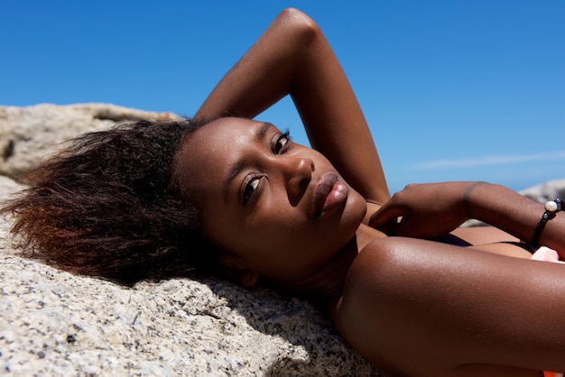 Beau modèle féminin africain couché sur le rocher