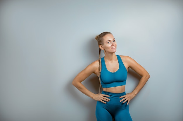 Beau modèle de fitness montrant l'espace de copie sur fond gris.