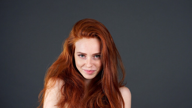 Photo beau modèle avec de longs cheveux roux raides brillants.