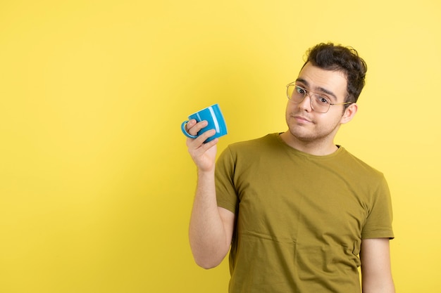 beau modèle masculin regardant une tasse de thé.