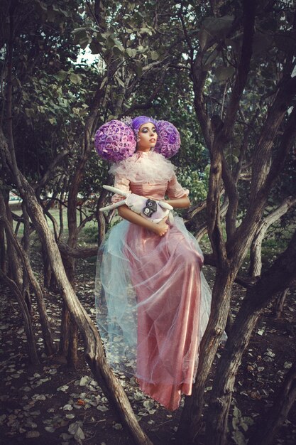 Photo beau modèle portant une robe rose posant avec une perruque violette