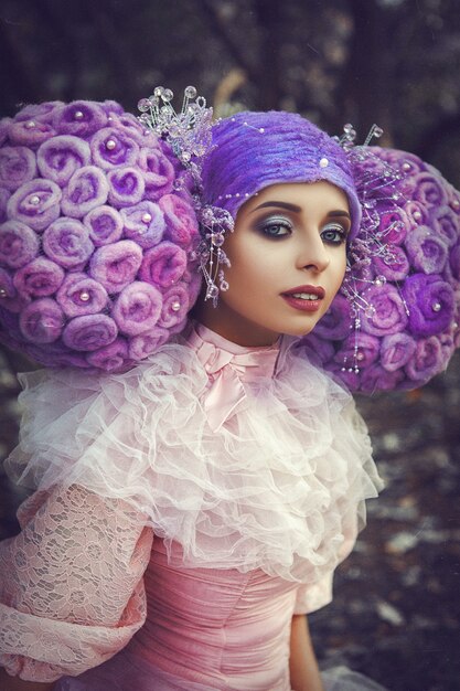 Photo beau modèle portant une robe rose pose dans une perruque créative