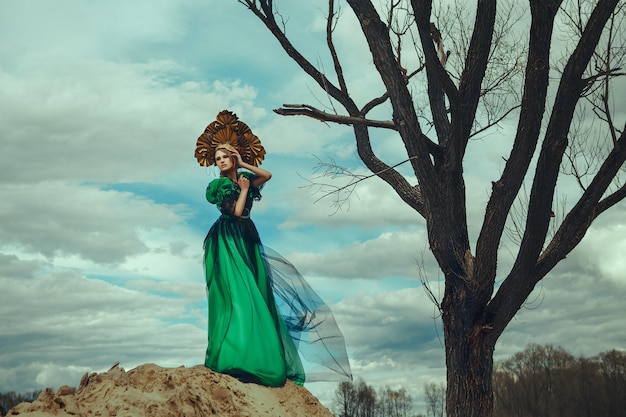 Beau modèle pose vêtu d'une robe verte et kokoshnik