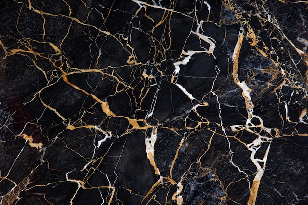 Un beau motif à la surface d'une dalle de marbre noir avec des veines jaunes et blanches appelée New Portoro.