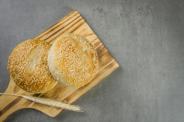 Beau pain au levain sur fond gris avec fleur de blé séchée