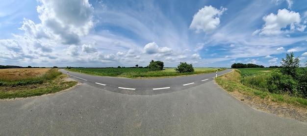Photo beau panorama à haute résolution d'une route de campagne d'europe du nord avec des champs et de l'herbe verte