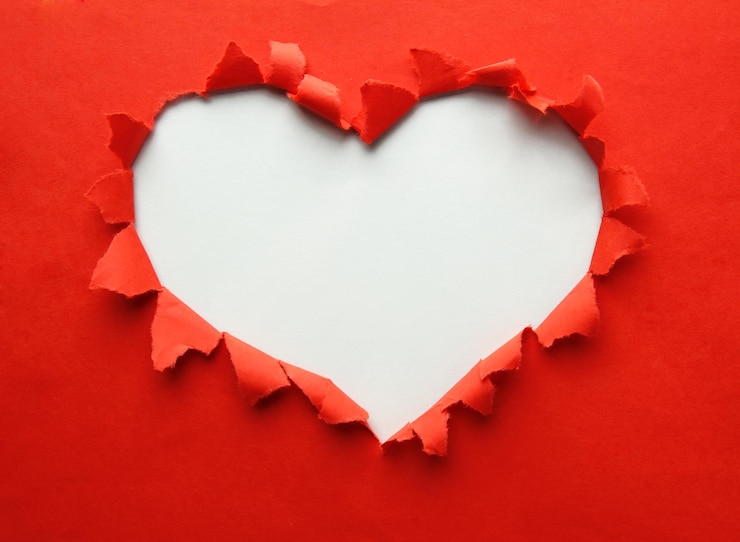 Photo beau papier déchiré dans le symbole de forme de coeur