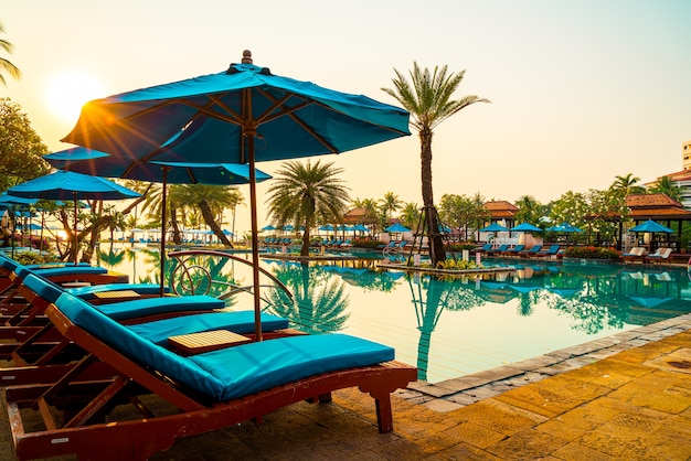 Beau parasol et chaise autour de la piscine de l'hôtel