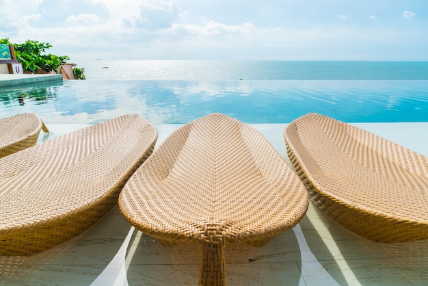 Beau parasol et chaise de luxe autour de la piscine extérieure de l&#39;hôtel et du complexe